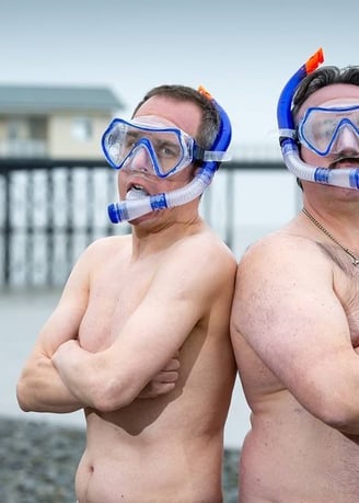 The Unexplainers posing in swimming trunks, weaking masks and snorkels