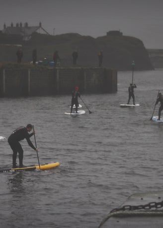 A paddle board race in Aberystwyth harbour on a grey December day