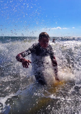 A young surfer nose diving close to the camera