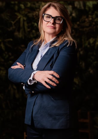 a woman in a suit and glasses posing for a photo
