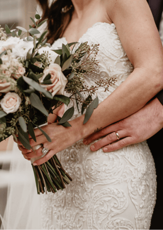 a bride and groom holding a bouquet of flowers