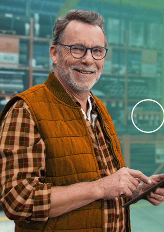 a man in a vest and glasses holding a cell phone