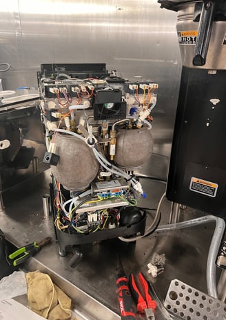 Super-automatic espresso machine opened for internal maintenance and repair in South Florida