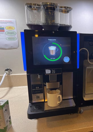 espresso machine setup preparing cappuccino with touchscreen interface.