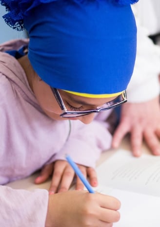 Elementray girl uses a workbook to share her thoughts.