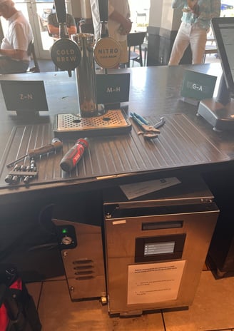  Nitro Cold Brew and Cold Brew tap system setup with tools on the counter at a coffee shop.
