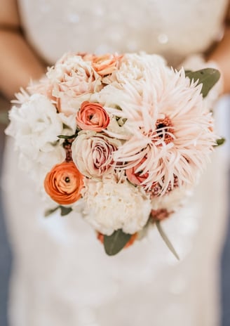 a bridesmael holding a bouquet of flowers