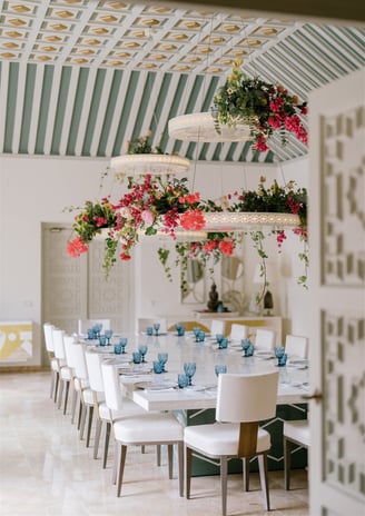 Dining room at Villa El Rincon featuring ornate ceilings with hanging lights and floral decorations for a destination wedding