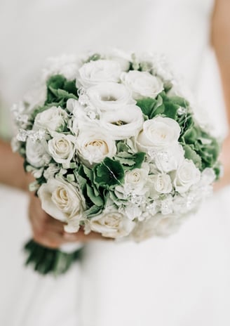 a bridesmael holding a bouquet of white roses