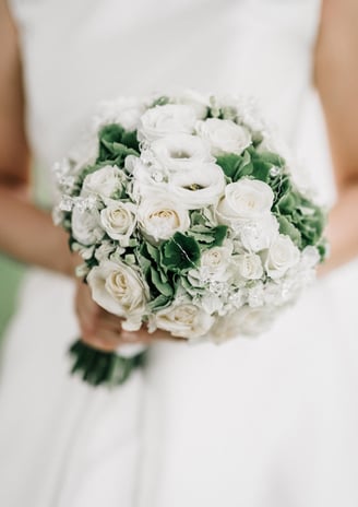 a bridesmael holding a bouquet of white roses