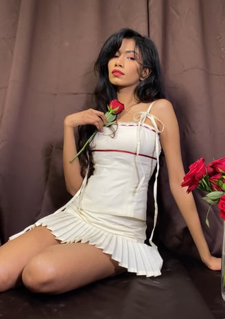 a woman in a white dress sitting on a couch