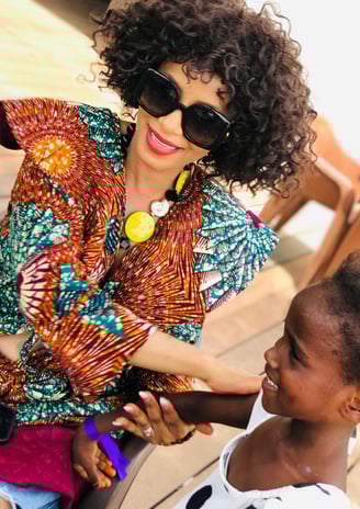 a woman in sunglasses and sunglasses is smiling and holding a child