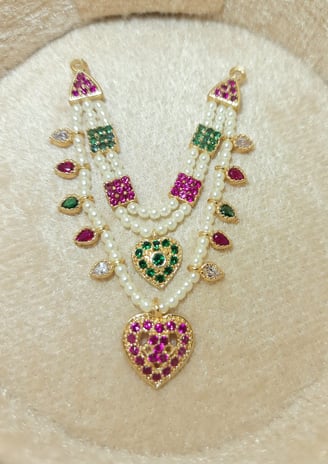 a necklace with a heart shaped pendant and a pearl necklace