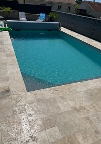 Piscine avec sol carrelé et décor serein en fond