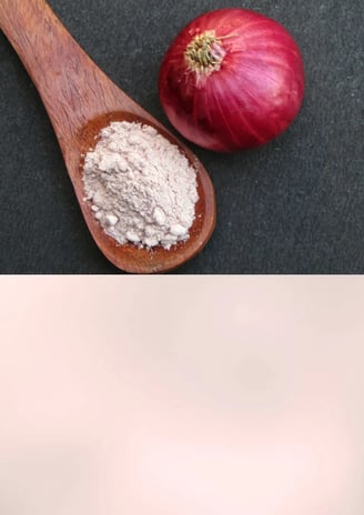 Fine white onion powder in a glass jar next to raw onions