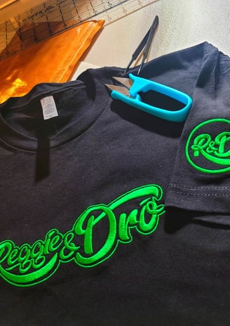 Black custom embroidered shirt with green Reggie & Don logo design – personalized embroidery by Stit