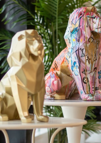 two statues of two lions sitting on a table