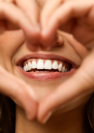 Person smiling confidently after a comprehensive smile makeover, featuring perfectly aligned and bri