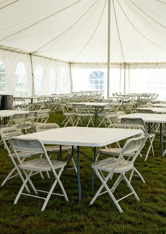 tables and chairs under a tent