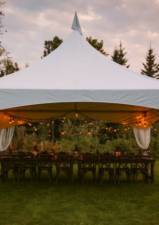 Carpa 20x20 en el patio de una casa, adornada con luces, sillas, mesas