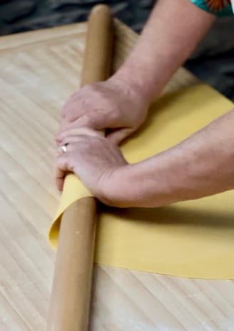 Close-up of Alessandra Spisni’s hands crafting handmade sfoglia, an Emilia-Romagna tradition.