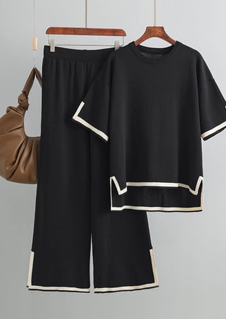 a pair of black pantsuits with a purse bag