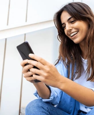 a woman sitting on steps with a cell phone