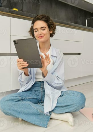 a woman sitting on the floor with a tablet computer and a tablet