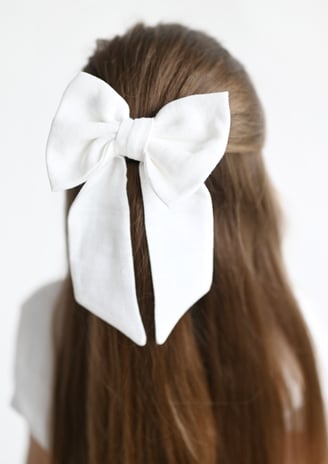 a woman with a white bow tie on her hair