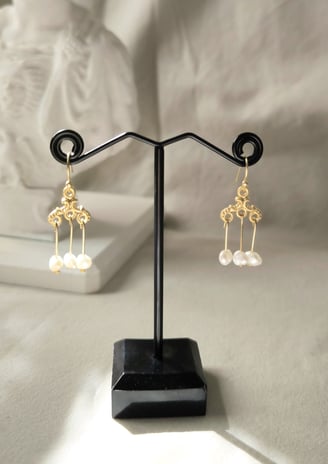 a pair of earrings with pearls and pearls