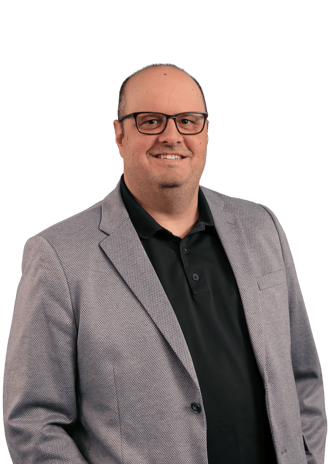 Michael Puccini in a suit and glasses smiling.
