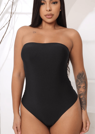 a woman in a black swimsuit with tattoos on her chest