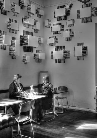 Peter Pickering snaps two ladies sitting at a table with drinks in a trendy cafe.