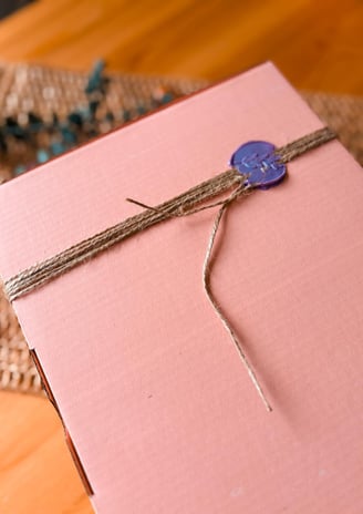 Elegant pink gift box sealed with a decorative wax stamp blue wax stamp, ideal for festive gifting