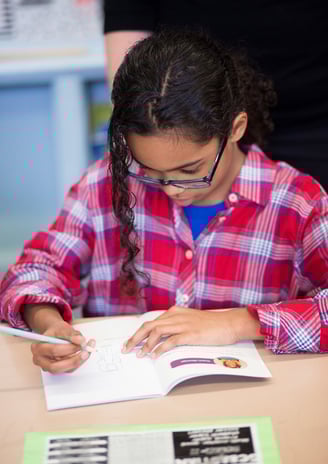 Elementary student reflects in a NaliniKIDS workbook.