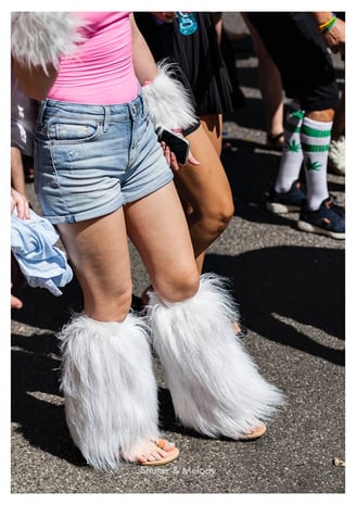 Eine Frau, die Beinwärmer aus Kunstpelz und Jeansshorts trägt.