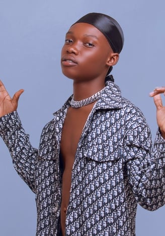 OliveTheBoy in a shirt with a chain around his neck.
