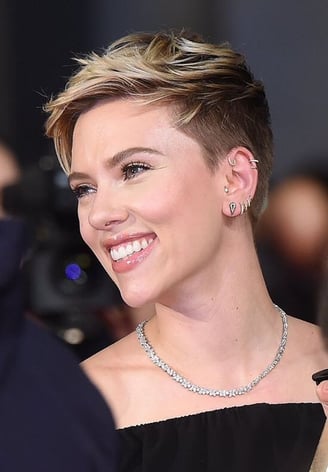 Close-up de mulher com corte de cabelo Pixie em tom platinado e raiz escura.