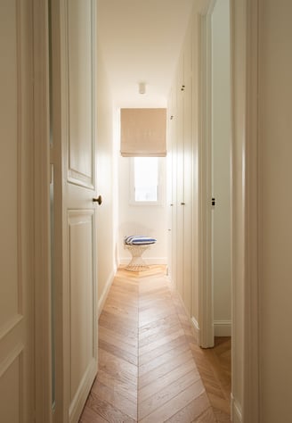 Couloir avec rangements sur mesure et parquet point de Hongrie dans un appartement à Paris