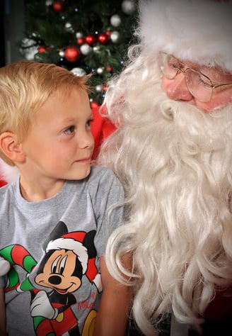 Peter Pickering's endearing photo of boy in a Mickey Mouse tee shirt gazing enquiringly at Santa