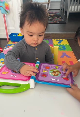 Photo of two children reading a book while at daycare.