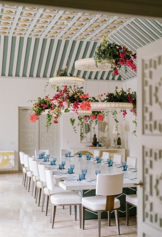 Dining room at Villa El Rincon featuring ornate ceilings with hanging lights and floral decorations for a destination wedding