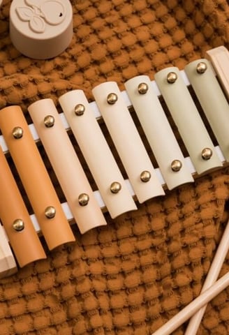 a musical instrument with a wooden mallet and a teddy bear