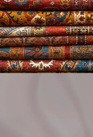 Traditional handwoven carpets with intricate patterns displayed on a showroom floor