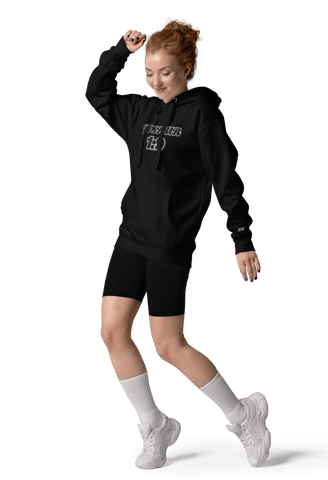 a woman in a black hoodie and shorts is jumping in the air