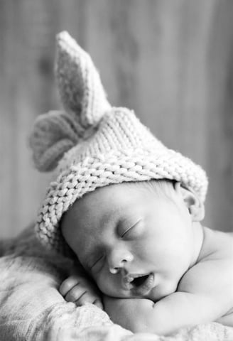 Bébé endormi en noir et blanc avec bonnet lapin – séance à domicile Gard