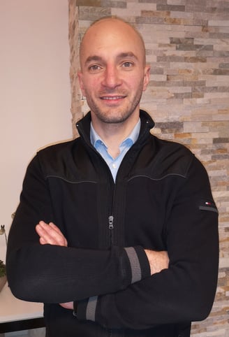 a man in a black jacket and a blue shirt