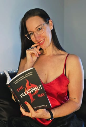 Pleasurelit Patricia with her book The Pleasurelit Way on her bed in lingerie.