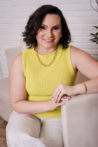 a woman in a yellow sweater and white pants