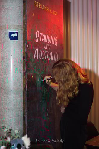 Eine Frau gestaltet ein Schild "Standing with Australia".